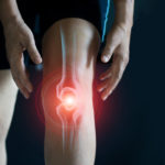 Elderly woman suffering from pain in knee. Tendon problems and Joint inflammation on dark background.