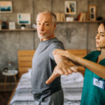 Older man doing exercises with his doctor