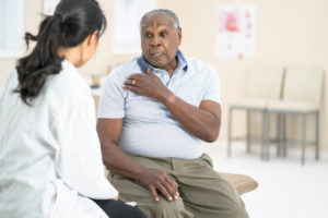 A man talking to his orthopedic doctor about a possible shoulder replacement procedure.