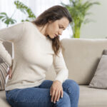 Young woman suffering with back pain