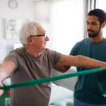 physiotherapist exercising with senior patient
