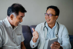 Image of Asian doctor visit home of a senior man patient and giving medical consultation