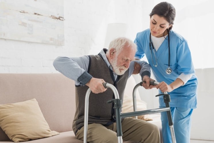 Elderly man with nurse suffering from orthopedic issues and aging. 