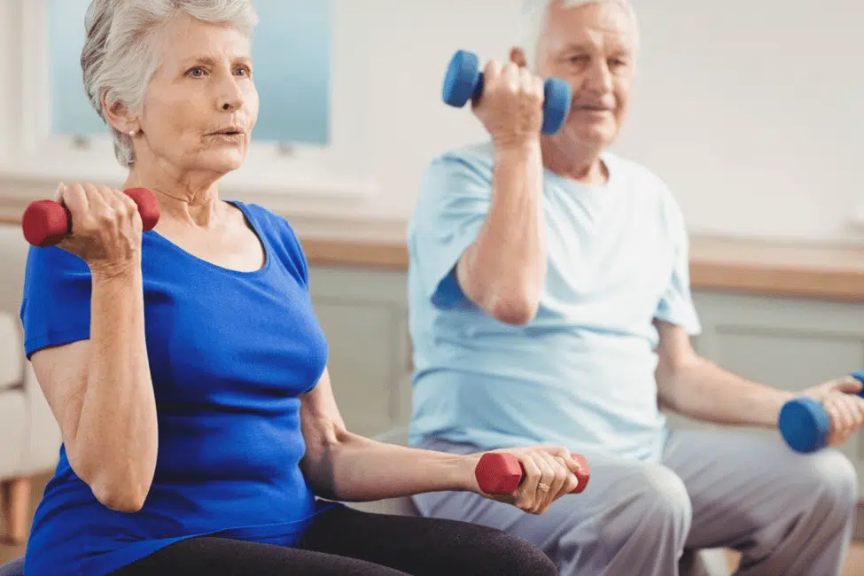 Elderly couple working out together with dumbbells to promote orthopedic healthy aging. 